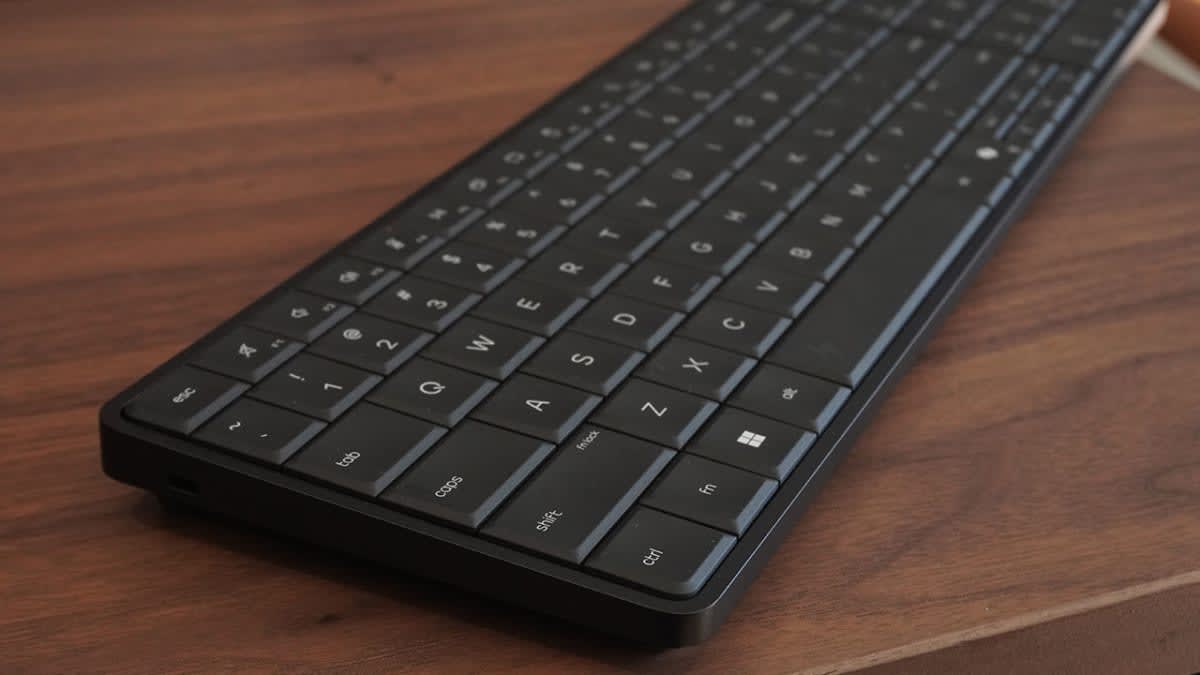 HP EliteBoard G1a keyboard PC on a wooden desk, viewed from a low angle